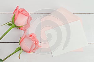 Blank greeting card with pink envelope and pink rose flowers