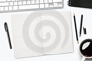 Blank grid lines notebook page on white desk. Top view, flat lay