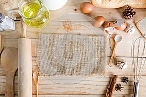 Blank hemp sackcloth and bakery ingredients on wooden table back photo