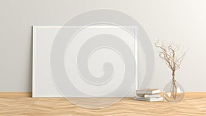 Blank horizontal poster frame mock up standing on light herringbone parquet floor next to white wall with vase and books.