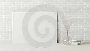 Blank horizontal poster frame mock up standing on white floor next to white brick wall with vase and books.