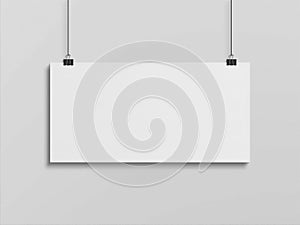 Blank horizontal poster hanging with clips on a white wall Mockup. 3D rendering