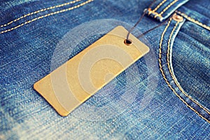 Blank label price tag mockup on blue jeans.