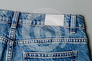 Blank leather jeans label sewed on a blue jeans. mockup