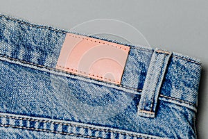 Blank leather jeans label sewed on a blue jeans. mockup