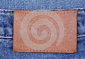 Blank leather label on jeans background