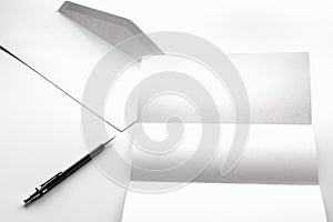 blank of letter paper and white envelope with pen