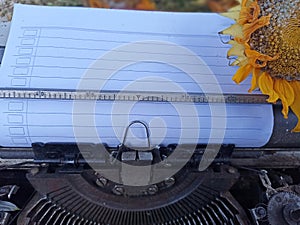 Blank line note paper on an old typewriter retro vintage with wilted sunflower. Life story concept