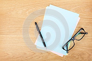 Blank lined paper with office supplies and glasses