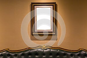 The blank luxury photo frame hanging on wall above the sofa, int