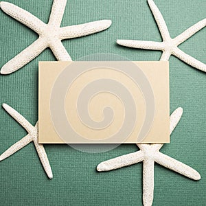 Blank memo pad and starfish on green background. summer marine decoration