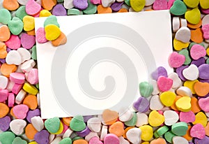 Blank note card surrounded, framed by candy hearts