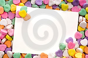 Blank note card surrounded, framed by candy hearts