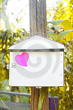 Blank note pad or sticky notes pink on post box with sunlight ba