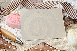 Blank note paper and pen decorated with brown ribbon on burlap s