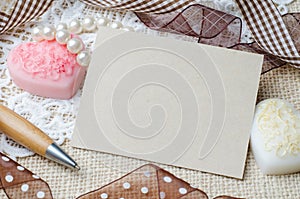Blank note paper and pen decorated with brown ribbon on burlap s