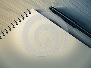 Blank note paper with pen. on wood background