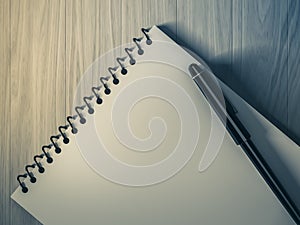 Blank note paper with pen. on wood background