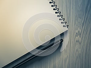 Blank note paper with pen. on wood background