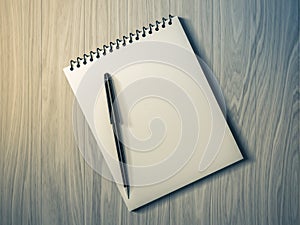 Blank note paper with pen. on wood background