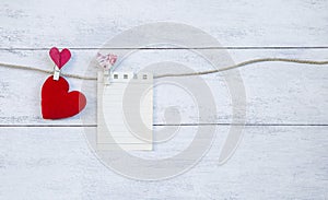 Blank note paper with red heart on white wooden table background