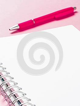 Blank note with pen on pink background