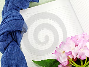 Blank notebook with artificial flower and scarft