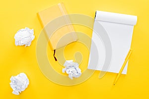 Blank notebook and crumbled paper balls