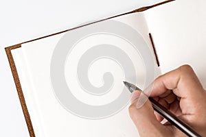 Blank notebook with hand holding pen