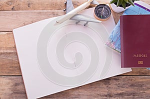 Blank notebook,passport,compass,airplane and map on wooden table