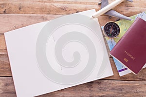 Blank notebook,passport,compass,airplane and map on wooden table