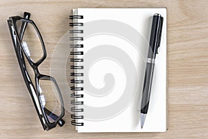 Blank notebook with pen and eye glasses