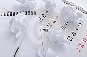 Blank notebook, pen, paper balls and calendar with marked date.Concept of finishing work on time