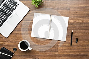 Blank notebook with pen are on top of wood office desk table. Top view, flat lay