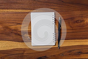 blank notebook and pen on wooden table