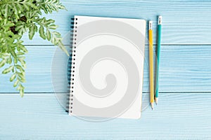 Blank notebook with and pencil on blue background,Flat lay photo