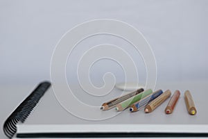 Blank notebook with pencil on white desk background,pencil and notebook with space for text or image, selective focus.