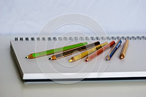 Blank notebook with pencil on white desk background,pencil and notebook with space for text or image, selective focus.