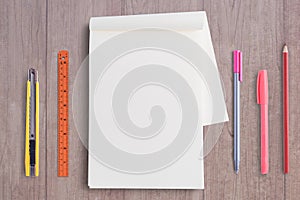 Blank notebook and school tools on  wood table background