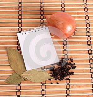 Blank notebook with spices on wooden background