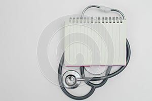Blank notebook on stethoscope white background. heart and healthcare concept. diagnostic, disease, cardiology. equipment research