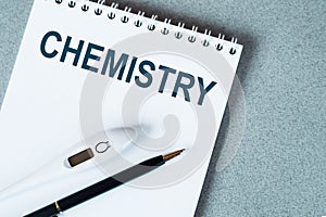 Blank notebook with thermometer and pen on table CHEMISTRY text