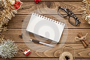 Blank notebook on  wood background with Christmas ornaments decorations. Mockup Christmas background with notebook for wish list