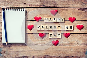 Blank notebook and wood text for Happy Valentine Day with red he