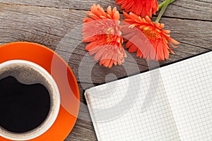 Blank notepad, coffee cup and orange gerbera flowers