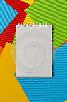 Blank notepad on the colored embossed paper sheets