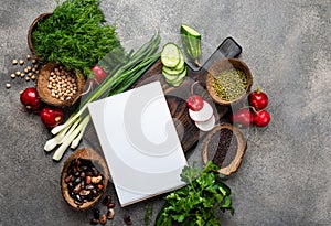 Blank notepad and fresh vegetables ingredients for veggie cooking.