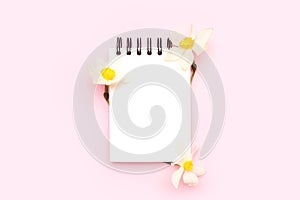 Blank notepad mockup with white narcissus flowers.