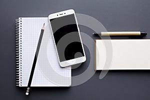 Blank notepad and notebook with smartphone, pencil and pen