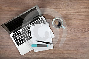 Blank notepad over laptop and coffee cup